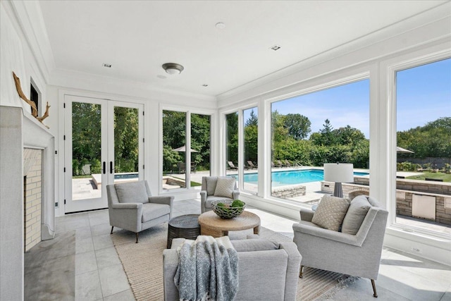 sunroom featuring a fireplace, french doors, and a healthy amount of sunlight