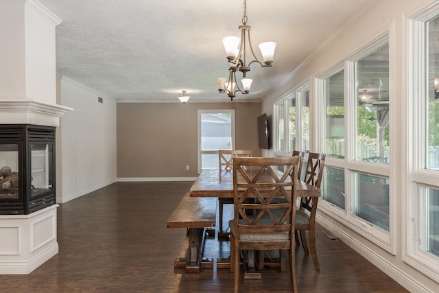 dining space featuring dark hardwood / wood-style floors, an inviting chandelier, and crown molding