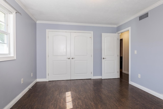 unfurnished bedroom featuring ornamental molding, a closet, and dark wood-type flooring