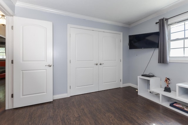 unfurnished bedroom featuring ornamental molding, a closet, and dark wood-type flooring