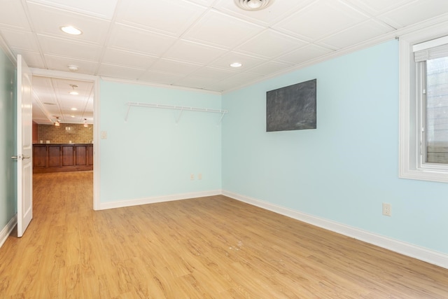 unfurnished room featuring light wood-type flooring and brick wall