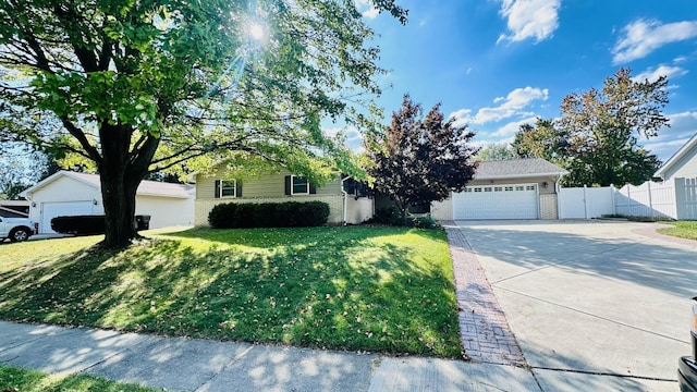 view of property hidden behind natural elements featuring a front lawn and a garage