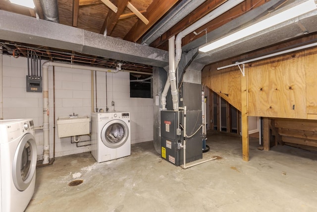 basement with washer and dryer, sink, and heating unit