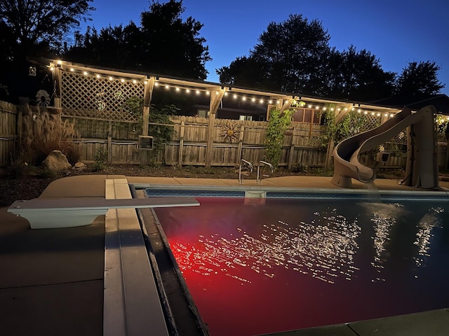 view of swimming pool featuring a diving board and a water slide