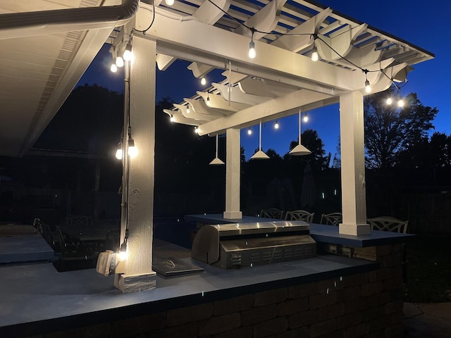 patio at twilight featuring exterior kitchen and grilling area