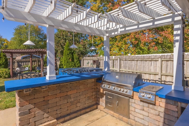 view of patio / terrace with exterior kitchen, a pergola, and grilling area