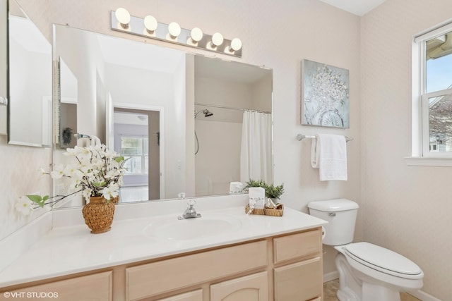 bathroom with walk in shower, vanity, and toilet