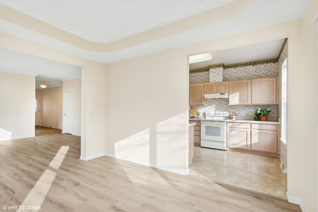 kitchen featuring a healthy amount of sunlight, white range with electric stovetop, backsplash, light hardwood / wood-style floors, and light brown cabinetry