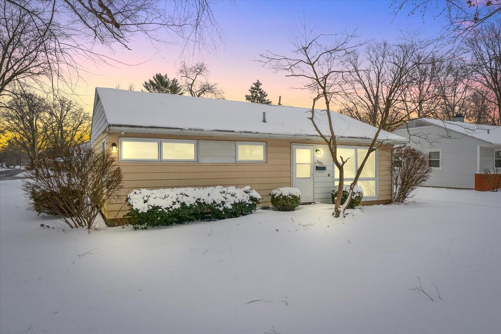 view of snow covered back of property