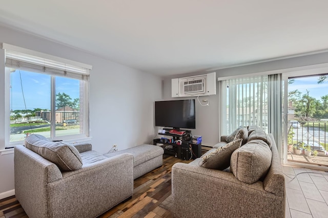 living room with hardwood / wood-style flooring, a wall mounted AC, and a healthy amount of sunlight