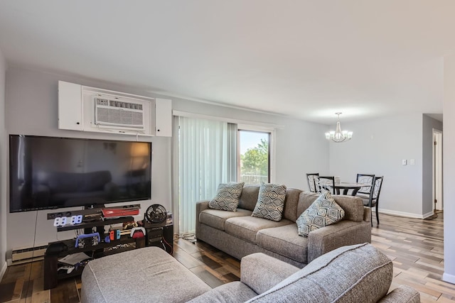 living room with a wall mounted AC, light hardwood / wood-style floors, and a notable chandelier