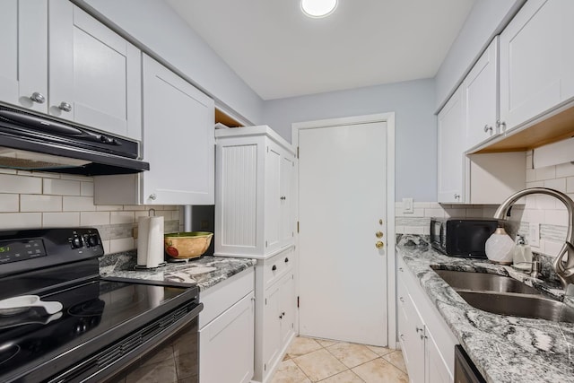 kitchen featuring light stone countertops, sink, light tile patterned floors, white cabinets, and black electric range oven