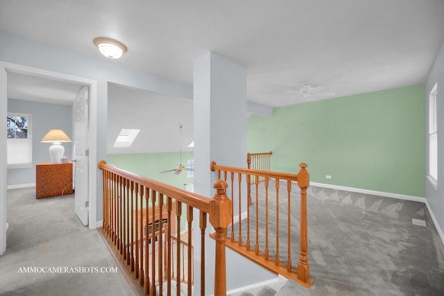 hallway featuring a skylight and light colored carpet