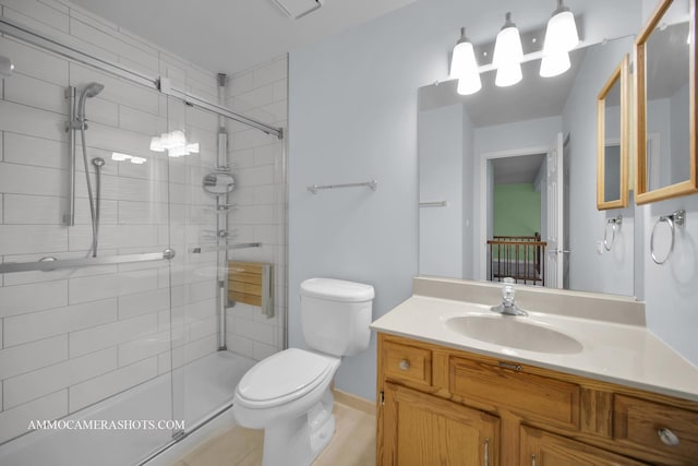 bathroom featuring tile patterned floors, vanity, toilet, and a shower with door