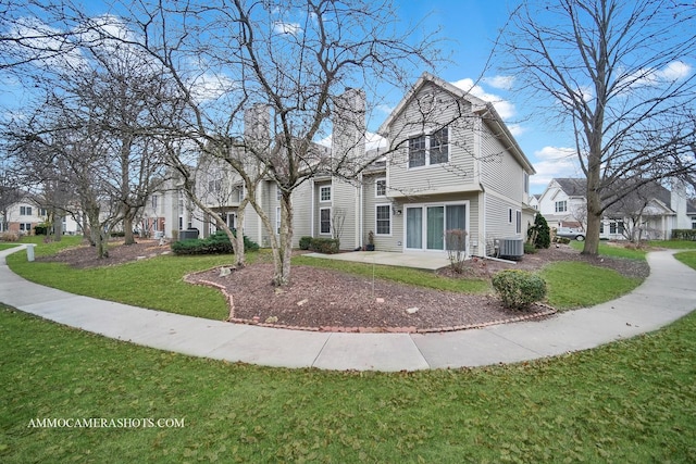 view of front property featuring a front yard, cooling unit, and a patio area