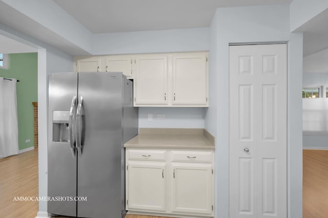 kitchen featuring stainless steel fridge, white cabinetry, and light hardwood / wood-style flooring