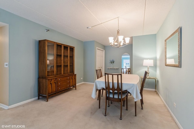 7041 W Touhy Ave Unit 209, Niles, IL 60714 - dining room featuring light colored carpet, a chandelier, arched walkways, and baseboards