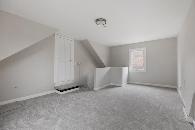 bonus room featuring light colored carpet and vaulted ceiling