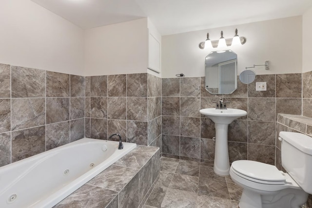 bathroom featuring tiled bath, toilet, and tile walls