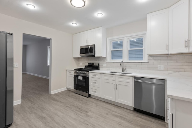 kitchen featuring white cabinets, light wood-type flooring, sink, and appliances with stainless steel finishes