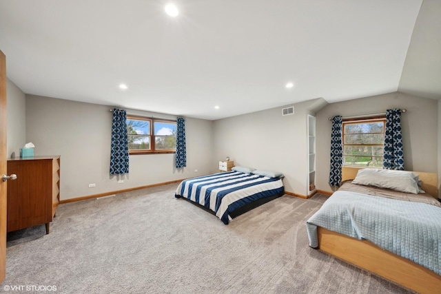 bedroom featuring light colored carpet and vaulted ceiling