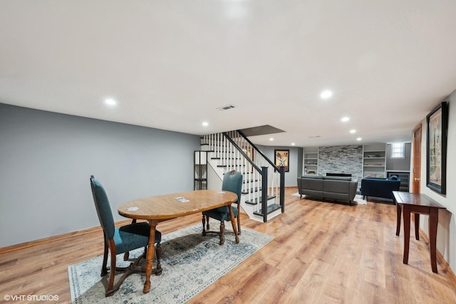 dining room featuring built in shelves and light hardwood / wood-style floors