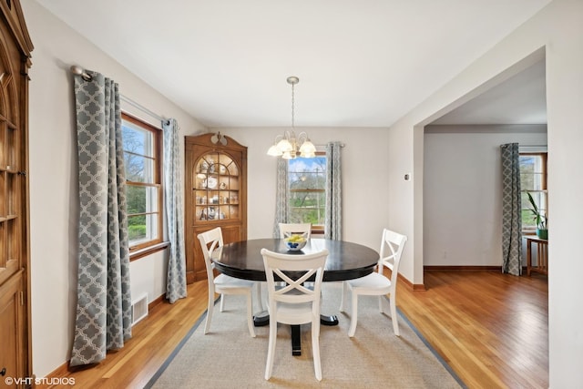 dining area featuring a notable chandelier and light hardwood / wood-style floors