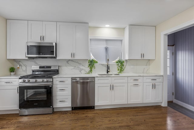 kitchen with dark wood-type flooring, white cabinetry, sink, and stainless steel appliances