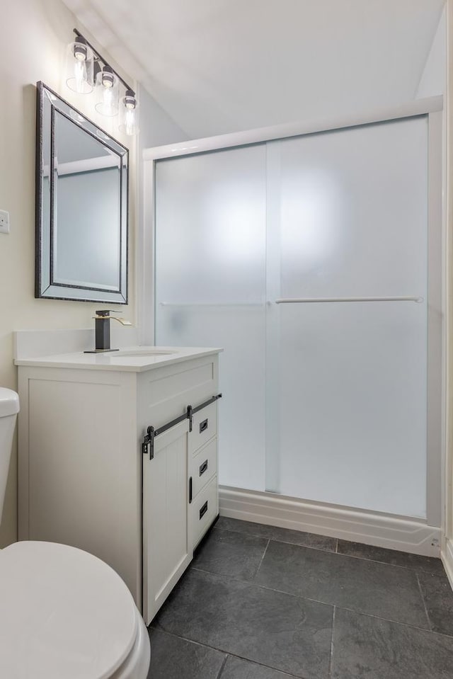 bathroom featuring vanity, toilet, and a shower with door