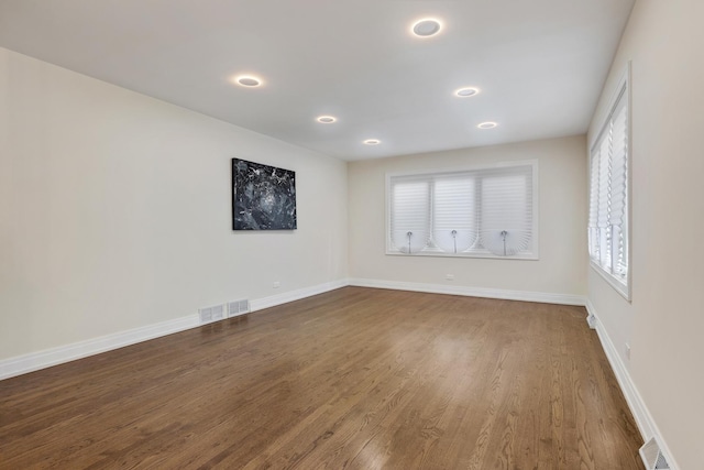 unfurnished room with hardwood / wood-style flooring and a wealth of natural light