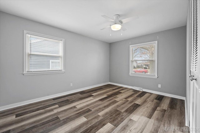 spare room with ceiling fan and dark wood-type flooring