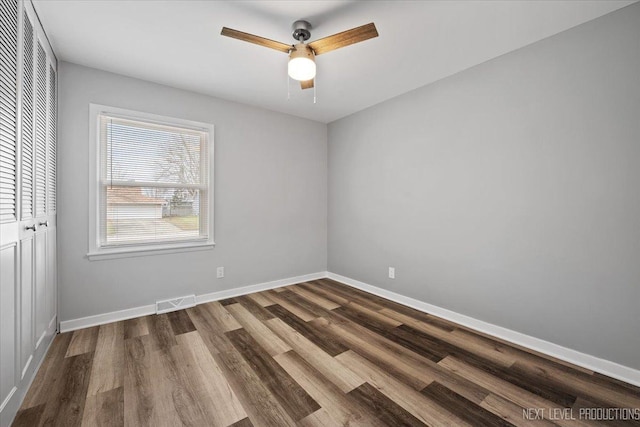 spare room featuring ceiling fan and dark hardwood / wood-style floors