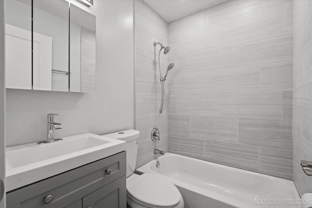 full bathroom with toilet, vanity, and tiled shower / bath