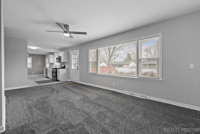 unfurnished living room featuring carpet and ceiling fan