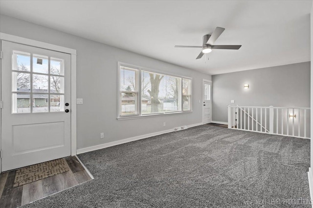 interior space with ceiling fan and dark colored carpet