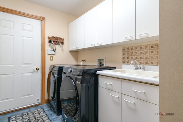 laundry room featuring sink, dark tile patterned floors, cabinets, and independent washer and dryer