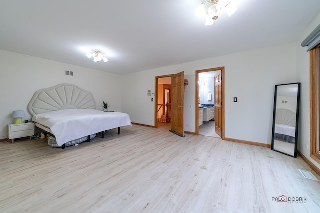 bedroom with ensuite bathroom and light hardwood / wood-style flooring