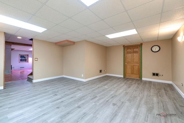 basement with light wood-type flooring and a drop ceiling