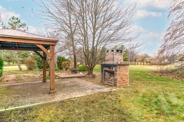 view of yard with an outdoor stone fireplace, a patio, and a gazebo