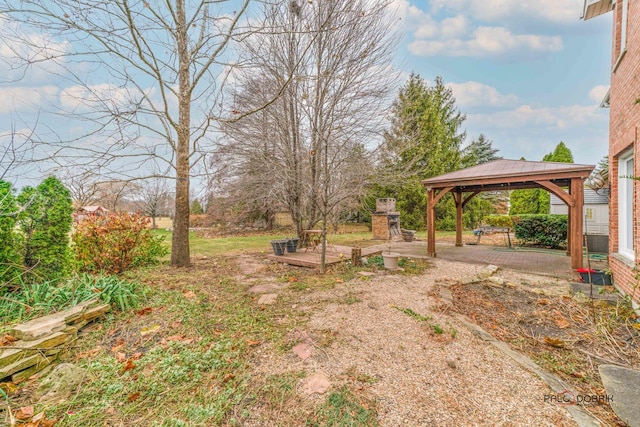 view of yard with a gazebo and an outdoor stone fireplace