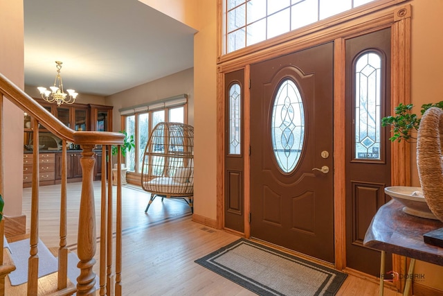 entrance foyer with light hardwood / wood-style floors and a chandelier