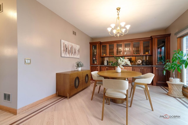 dining room featuring an inviting chandelier and light wood-type flooring