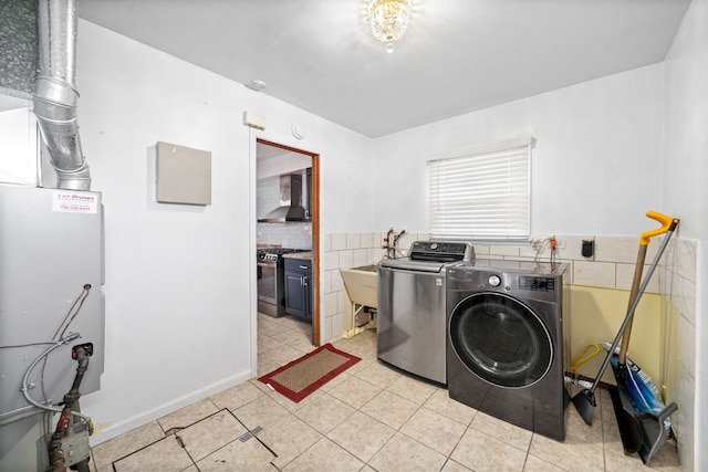 clothes washing area featuring washing machine and dryer and light tile patterned flooring