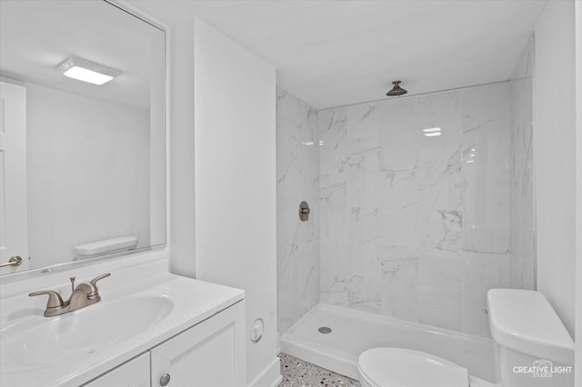 bathroom featuring a shower, vanity, and toilet