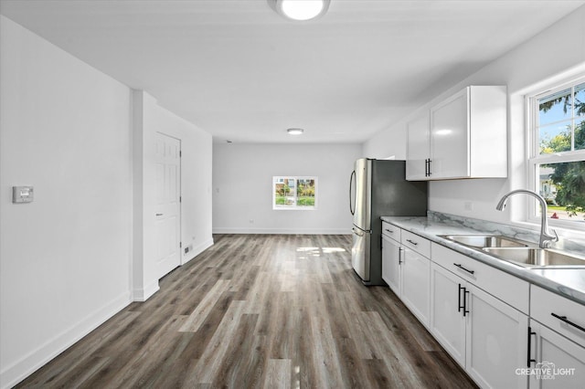 kitchen featuring stainless steel refrigerator, white cabinetry, sink, and dark hardwood / wood-style flooring