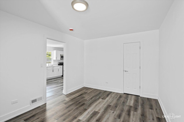 empty room with sink and dark hardwood / wood-style floors