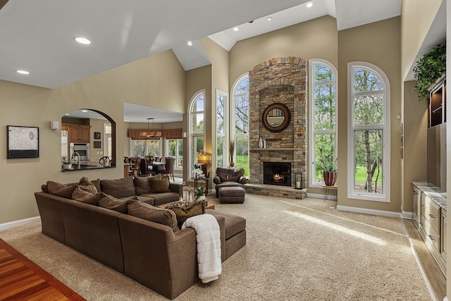 living room with a towering ceiling and a fireplace