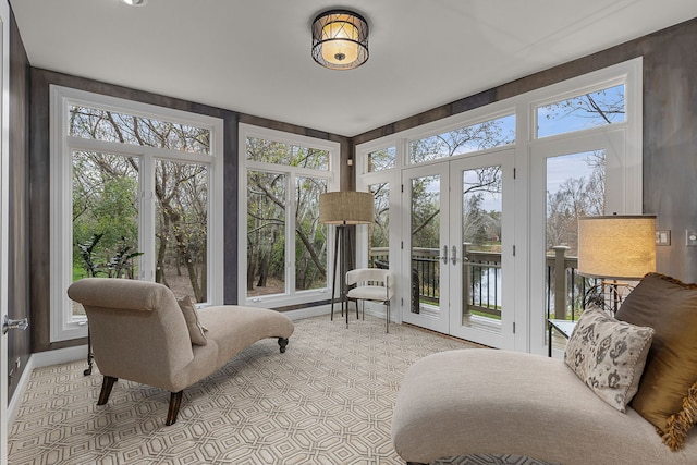 sunroom / solarium featuring a water view and french doors