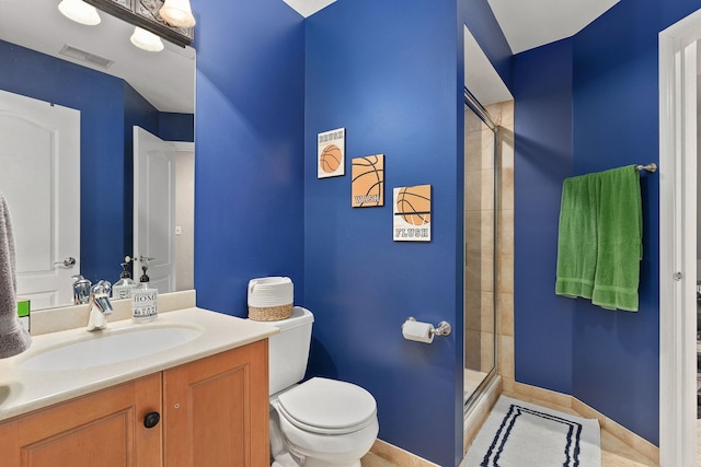 bathroom featuring vanity, a shower with door, and toilet