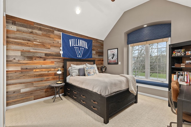 carpeted bedroom featuring lofted ceiling and wood walls